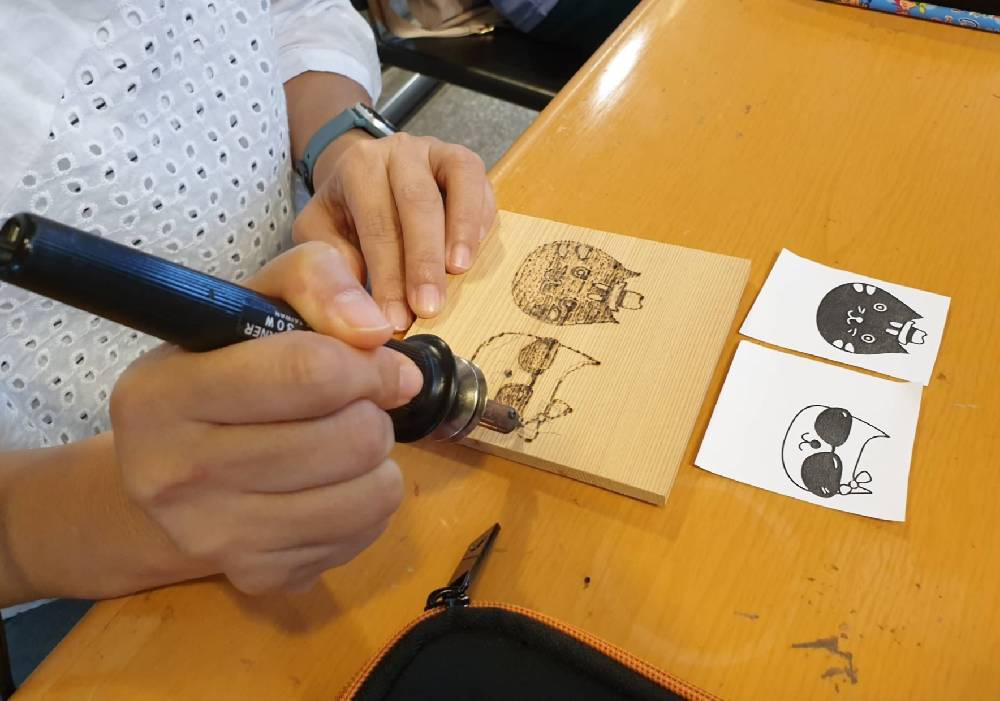 總館「原木動物繪烙畫DIY」活動引導親子在雪松上烙出喜愛的動物畫