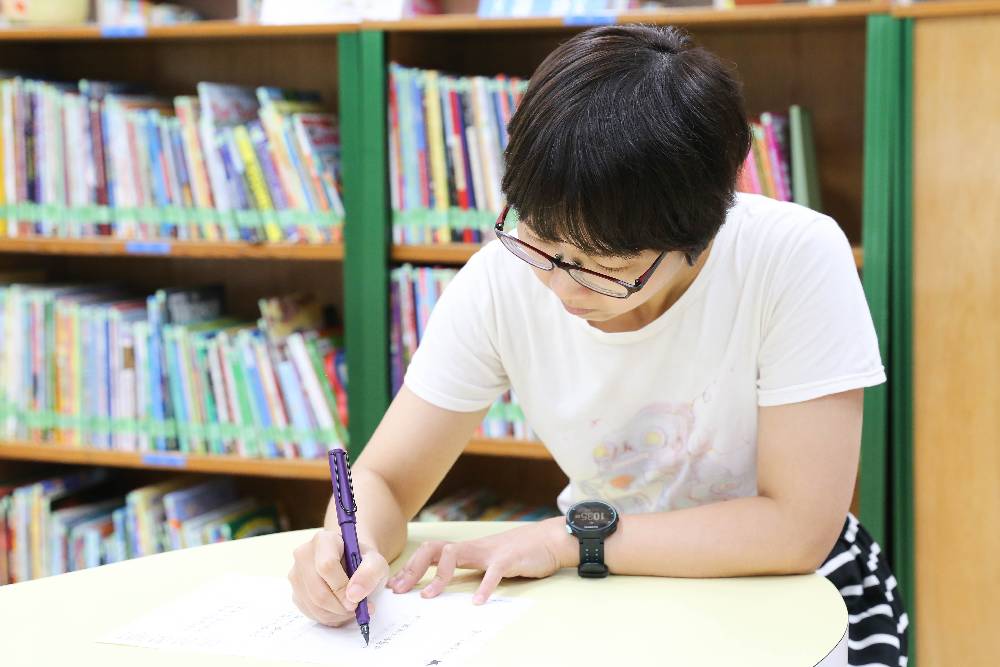 讀者在圖書館練習寫字